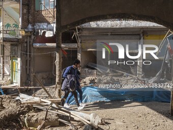 An Iranian man and woman are walking past destroyed shops along a collapsed street while visiting the flooded village of Imamzadeh Davood in...