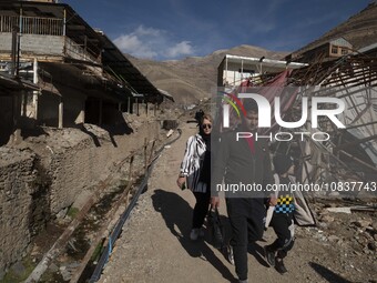 An Iranian family is walking past destroyed shops along a collapsed street while visiting the flooded village of Imamzadeh Davood in the nor...