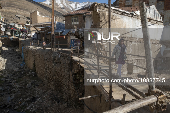 An Iranian woman is walking past destroyed shops along a collapsed street while visiting the flooded village of Imamzadeh Davood in the nort...