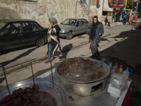 Two Iranian female tourists are walking past a vendor at a bazaar while visiting the flooded village of Imamzadeh Davood in the northwestern...