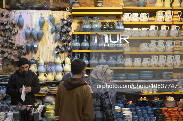 An Iranian woman is pointing at clay dishes while shopping at a bazaar in the flooded village of Imamzadeh Davood, in the northwestern part...