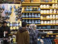 An Iranian woman is pointing at clay dishes while shopping at a bazaar in the flooded village of Imamzadeh Davood, in the northwestern part...