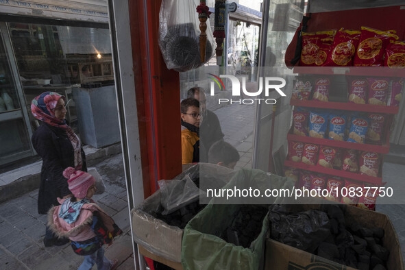 An Iranian family is standing in front of a supermarket at a bazaar in the flooded village of Imamzadeh Davood in the northwestern part of T...