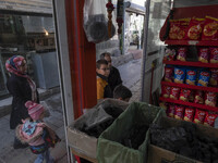 An Iranian family is standing in front of a supermarket at a bazaar in the flooded village of Imamzadeh Davood in the northwestern part of T...