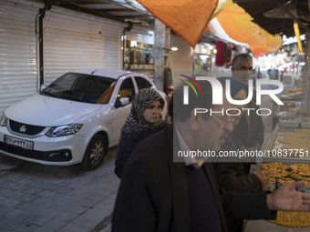 An Iranian family is standing in front of a traditional sweet shop at a bazaar in the flooded village of Imamzadeh Davood in the northwester...