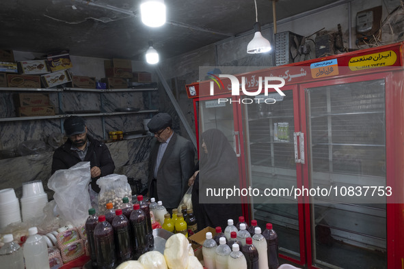 An Iranian man and an elderly veiled woman are shopping at a bazaar in the flooded village of Imamzadeh Davood in the northwestern part of T...