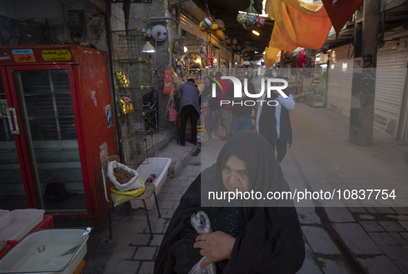 An elderly Iranian woman is walking through a bazaar in the flooded village of Imamzadeh Davood, in the northwestern part of Tehran, on Dece...