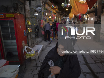 An elderly Iranian woman is walking through a bazaar in the flooded village of Imamzadeh Davood, in the northwestern part of Tehran, on Dece...