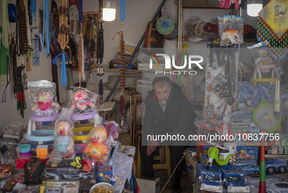 An Iranian salesman is sitting at a toyshop in a bazaar in the flooded village of Imamzadeh Davood, in the northwestern part of Tehran, on D...