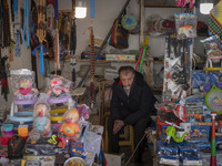 An Iranian salesman is sitting at a toyshop in a bazaar in the flooded village of Imamzadeh Davood, in the northwestern part of Tehran, on D...