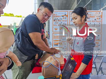 Participants are practicing cardiopulmonary resuscitation (CPR) at the 2023 China-ASEAN Health Industry Summit in Nanning, Guangxi, China, o...