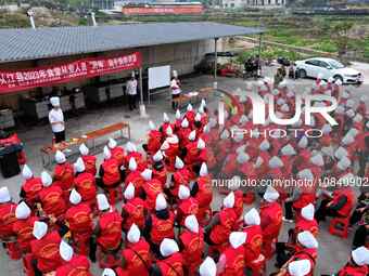 A mechanic teacher is training workers on cooking skills at a primary and secondary school canteen in Qiandongnan, Guizhou Province, China,...