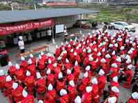 A mechanic teacher is training workers on cooking skills at a primary and secondary school canteen in Qiandongnan, Guizhou Province, China,...