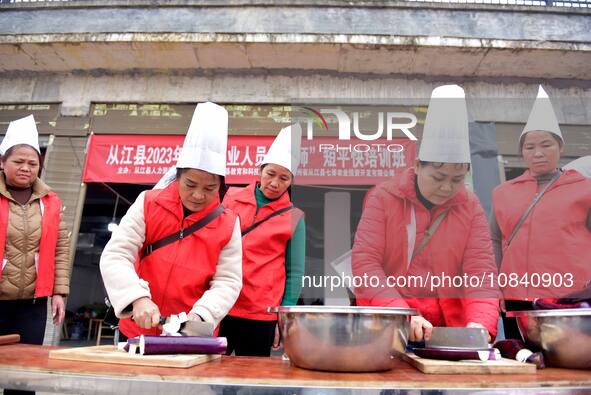 A mechanic teacher is training workers on cooking skills at a primary and secondary school canteen in Qiandongnan, Guizhou Province, China,...