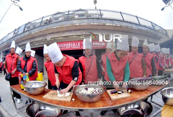 A mechanic teacher is training workers on cooking skills at a primary and secondary school canteen in Qiandongnan, Guizhou Province, China,...