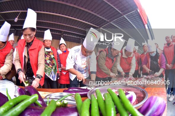 A mechanic teacher is training workers on cooking skills at a primary and secondary school canteen in Qiandongnan, Guizhou Province, China,...