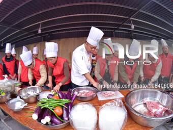 A mechanic teacher is training workers on cooking skills at a primary and secondary school canteen in Qiandongnan, Guizhou Province, China,...