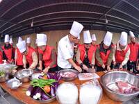 A mechanic teacher is training workers on cooking skills at a primary and secondary school canteen in Qiandongnan, Guizhou Province, China,...