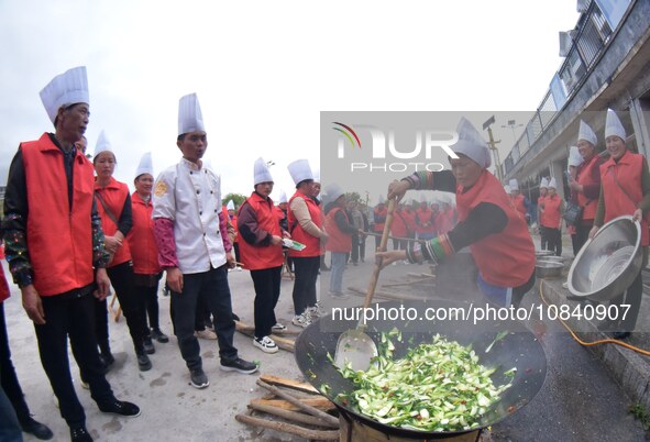 A mechanic teacher is training workers on cooking skills at a primary and secondary school canteen in Qiandongnan, Guizhou Province, China,...