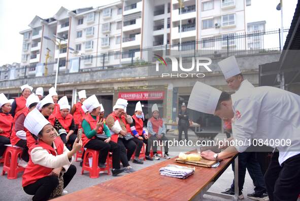 A mechanic teacher is training workers on cooking skills at a primary and secondary school canteen in Qiandongnan, Guizhou Province, China,...