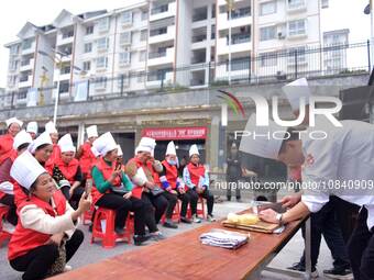 A mechanic teacher is training workers on cooking skills at a primary and secondary school canteen in Qiandongnan, Guizhou Province, China,...