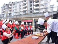 A mechanic teacher is training workers on cooking skills at a primary and secondary school canteen in Qiandongnan, Guizhou Province, China,...