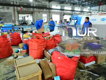 Workers are sorting items to be delivered at an express delivery company in Taicang, Jiangsu Province, China, on December 11, 2023. (