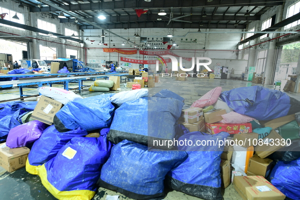 Workers are sorting items to be delivered at an express delivery company in Taicang, Jiangsu Province, China, on December 11, 2023. 