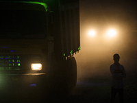 A pedestrian is standing along a dusty road in Dhaka, Bangladesh, on December 5, 2023. (