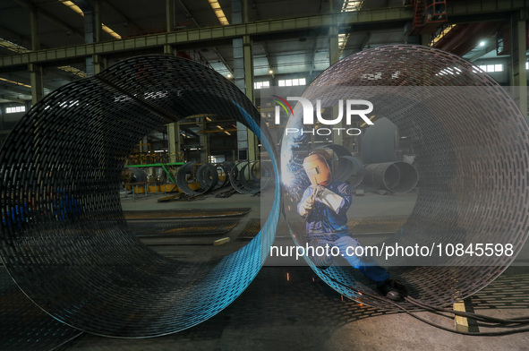 A worker is welding steel components of an air separation plant in Huzhou, Zhejiang Province, China, on December 12, 2023. 