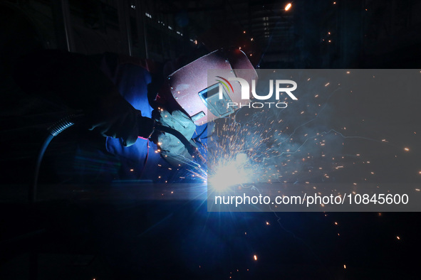 A worker is welding steel components of air separation equipment in Huzhou, Zhejiang Province, China, on December 12, 2023. 