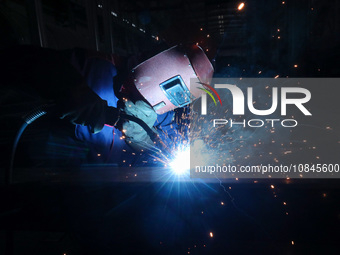 A worker is welding steel components of air separation equipment in Huzhou, Zhejiang Province, China, on December 12, 2023. (