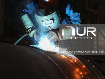 A worker is welding steel components of air separation equipment in Huzhou, Zhejiang Province, China, on December 12, 2023. (