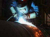 A worker is welding steel components of air separation equipment in Huzhou, Zhejiang Province, China, on December 12, 2023. (