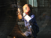 A worker is welding steel components of air separation equipment in Huzhou, Zhejiang Province, China, on December 12, 2023. (