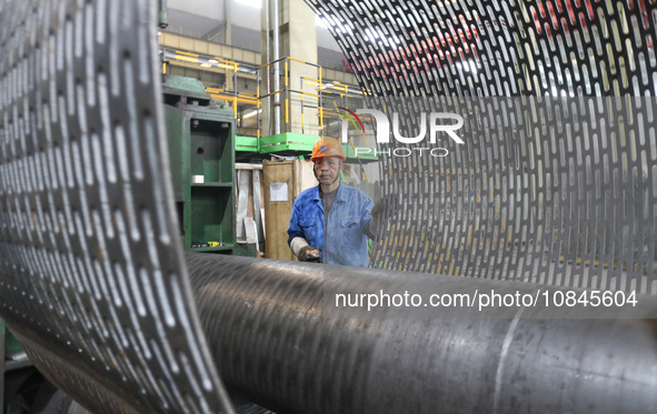 A worker is producing air separation equipment for export to Turkey in Huzhou, Zhejiang Province, China, on December 12, 2023. 