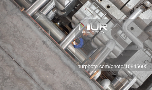 A worker is producing air separation equipment for export to Turkey in Huzhou, Zhejiang Province, China, on December 12, 2023. 