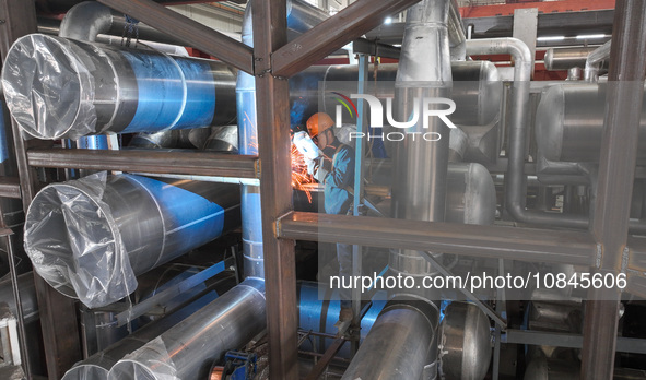 A worker is producing air separation equipment for export to Turkey in Huzhou, Zhejiang Province, China, on December 12, 2023. 