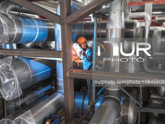 A worker is producing air separation equipment for export to Turkey in Huzhou, Zhejiang Province, China, on December 12, 2023. (