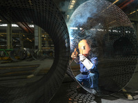 A worker is welding steel components of air separation equipment in Huzhou, Zhejiang Province, China, on December 12, 2023. (