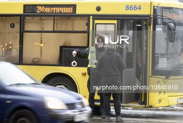 In Kyiv, Ukraine, on December 11, 2023, a police officer is talking to the driver of a bus that is operating between the closed metro statio...