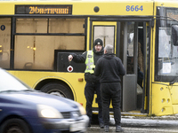 In Kyiv, Ukraine, on December 11, 2023, a police officer is talking to the driver of a bus that is operating between the closed metro statio...