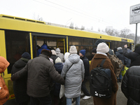 Passengers are getting on a bus that is operating between the closed metro stations of the Blue Line in Kyiv, Ukraine, on December 11, 2023....