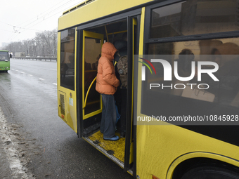 Passengers are getting on a bus that is operating between the closed metro stations of the Blue Line in Kyiv, Ukraine, on December 11, 2023....