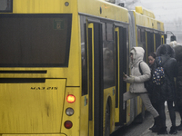 Passengers are getting on a bus that is operating between the closed metro stations of the Blue Line in Kyiv, Ukraine, on December 11, 2023....