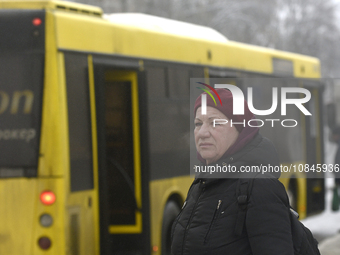 A woman is standing at a stop in Kyiv, Ukraine, on December 11, 2023, as additional buses and trolleybuses are operating between the closed...