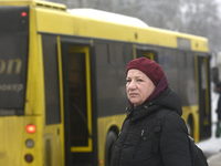 A woman is standing at a stop in Kyiv, Ukraine, on December 11, 2023, as additional buses and trolleybuses are operating between the closed...