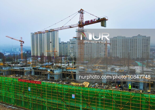 Workers are stepping up construction at the resettlement area project site in Yuexi County, Anqing City, Anhui Province, China, on December...