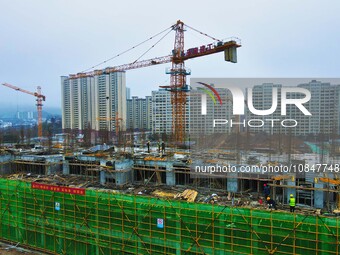 Workers are stepping up construction at the resettlement area project site in Yuexi County, Anqing City, Anhui Province, China, on December...