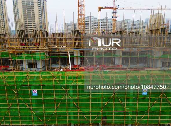 Workers are stepping up construction at the resettlement area project site in Yuexi County, Anqing City, Anhui Province, China, on December...